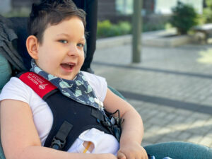 Mikaere in his wheelchair, laughing